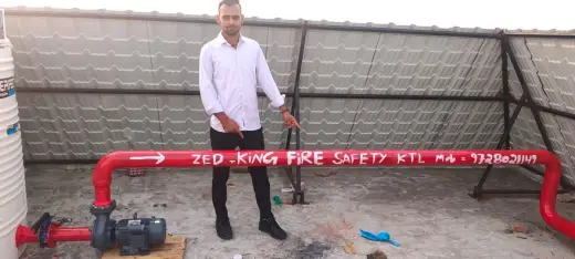 Zed-King team member at a completed rooftop fire pump and pipeline installation — Zed-King Institute of Fire And Safety gallery